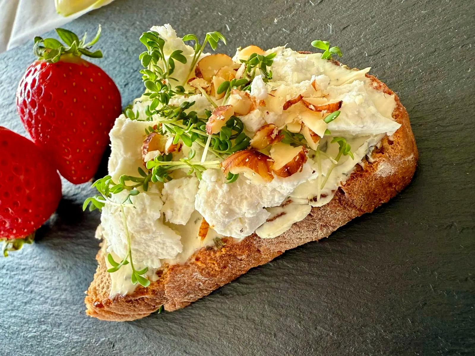 Belegtes Brot mit Frischkäse, Nüssen und Erdbeere