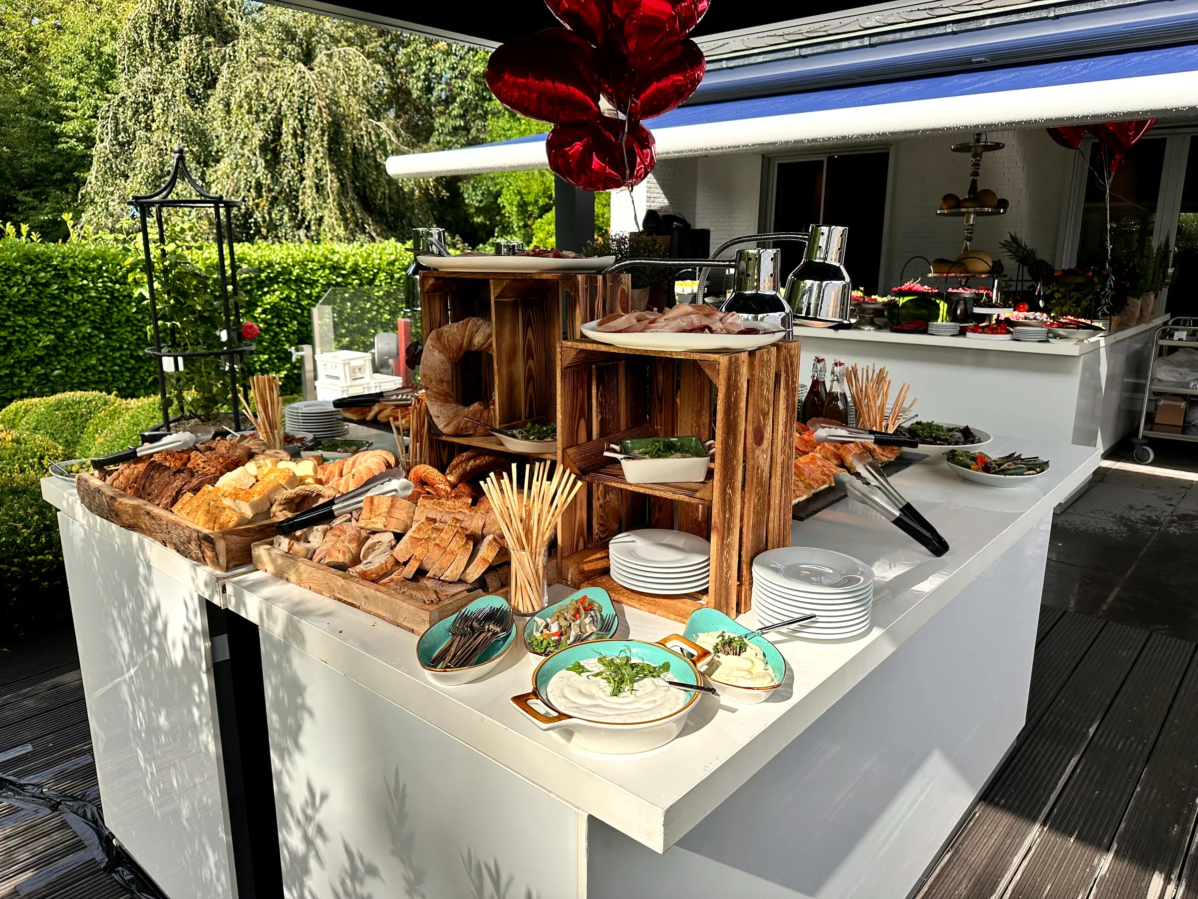 Sommerliches Buffet mit Broten, Aufstrichen und frischen Kräutern im Freien
