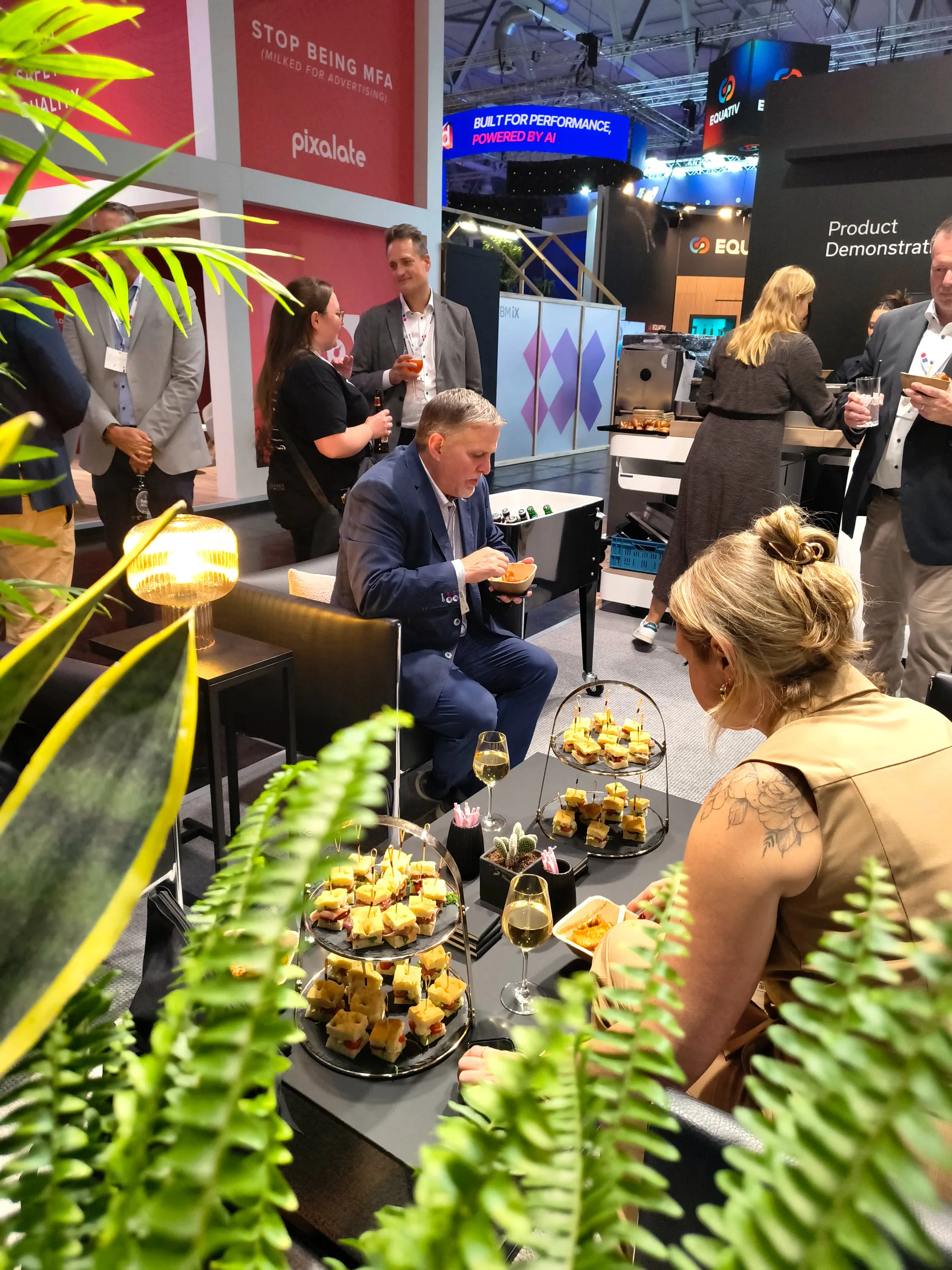 Fingerfood-Etagere auf einem Messestand mit Gästen